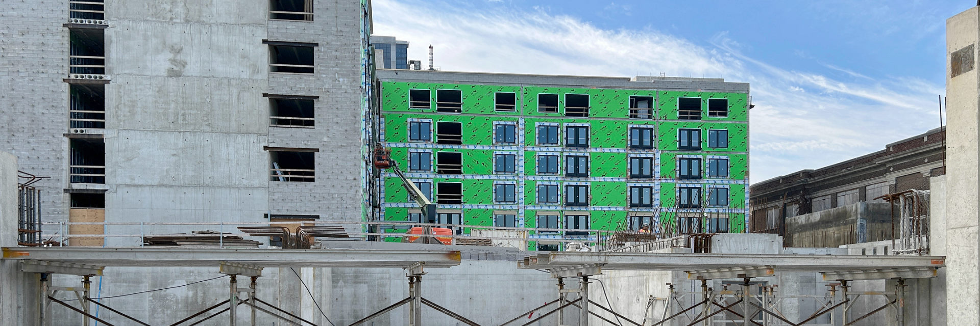 Construction site at 370 South Street in London Ontario SoHo around October 2024 with all six levels of the SoHo Zerin Place complete; a construction worker on a boom. As a partner in the Vision SoHo Alliance, Zerin is in the process of developing a 119 unit apartment building on South Street in London, Ontario.