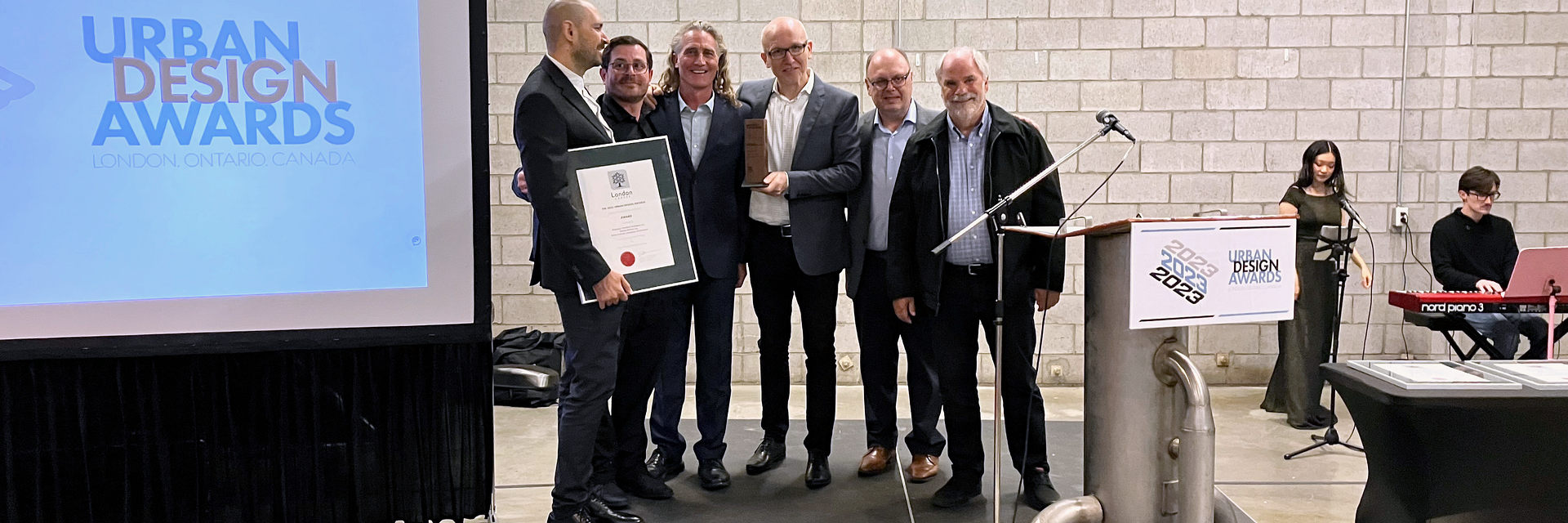 440 Clarke Rd receives an Urban Design Award in 2023 for its excellence in design in London, Ontario. The people and organizations receiving the award in the photo are as follows: Left to right:  Petar Sezar, Dustin Parkes, Art Lierman, Tim Wickens, Harry Froussios and Greg Playford. Organizations represented here are Nicholson Sheffield Architects, Arthur Lierman Landscape Architects, Zelinka Priamo Ltd. and Devonshire Consulting.